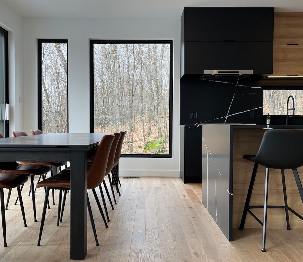 View of the open concept living space, kitchen and dining room, La Maison sur la falaise, Biophile architecture