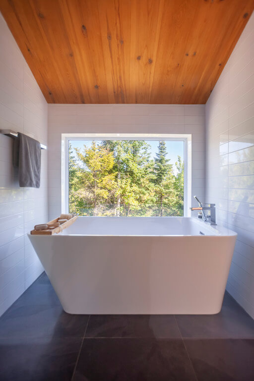 Vue de la baignoire auto-portante de la salle de bain à l'étage, projet La Grive réalisé par Biophile architecture